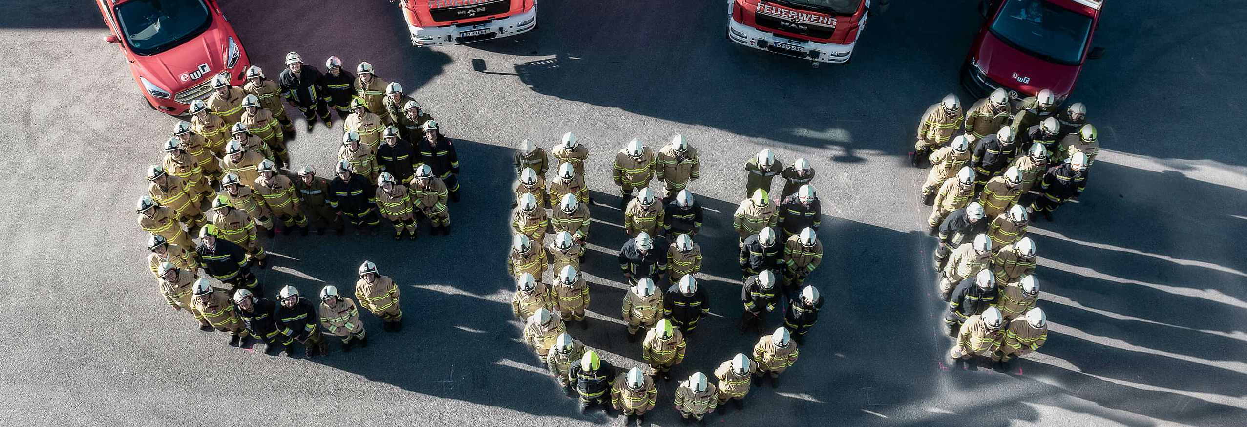 Vogelperspektive Feuerwehrmitglieder bilden Buchstaben ewr