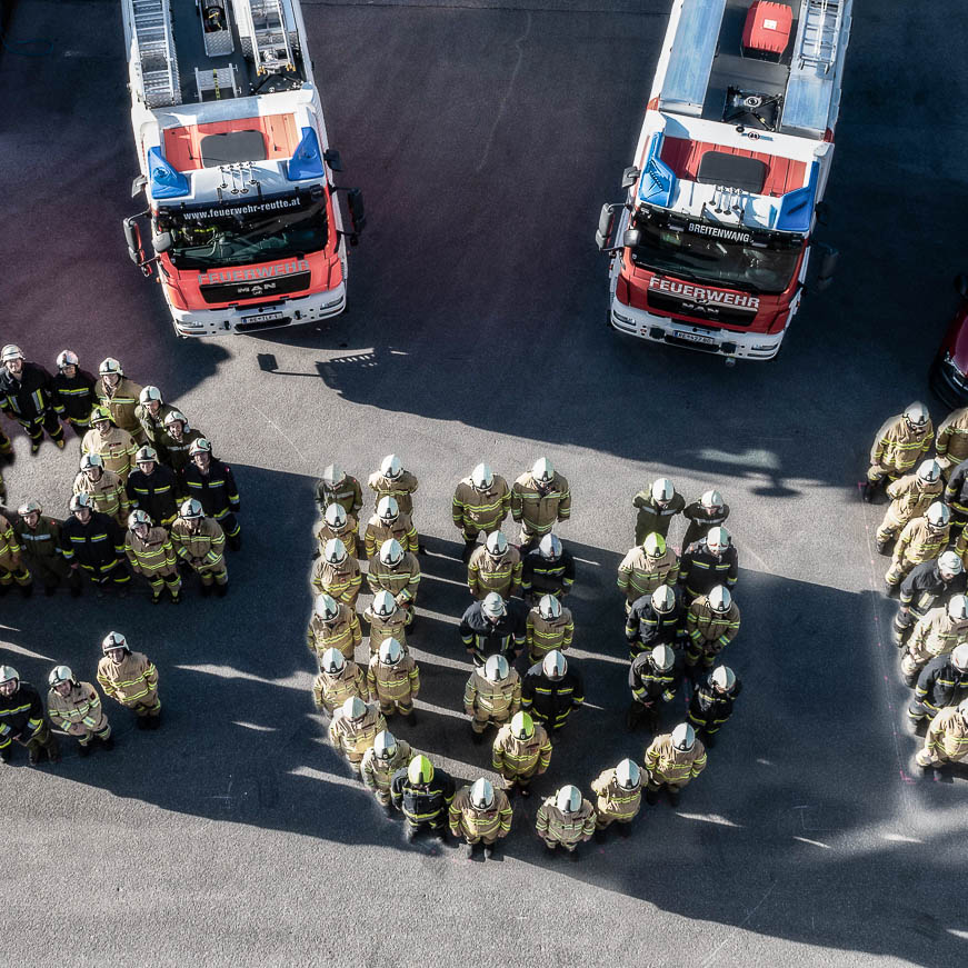 Vogelperspektive Feuerwehrmitglieder bilden Buchstaben ewr