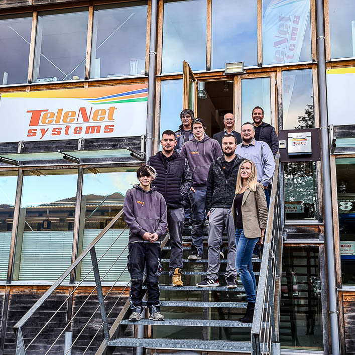 Gruppenbild auf Treppe vor Firmengebäude Telenet Systems